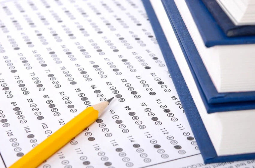 A pencil lies on top of multiple-choice answer sheets.